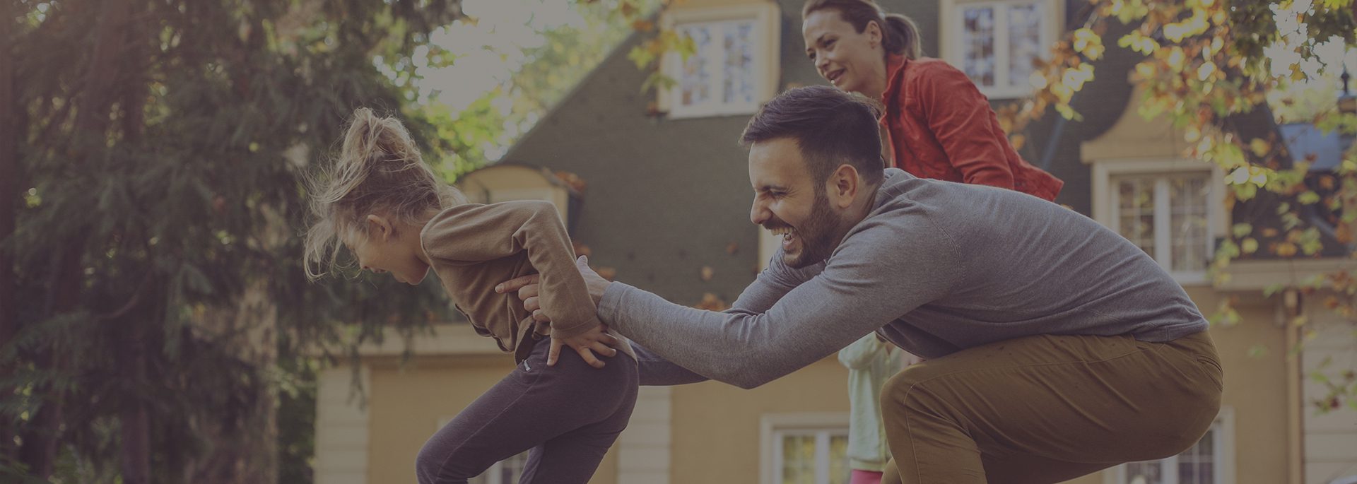 A man holding onto another person while he is playing with him