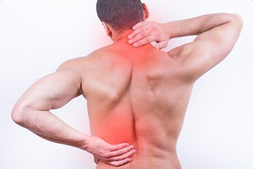 A man with his back turned holding on to the side of his neck.