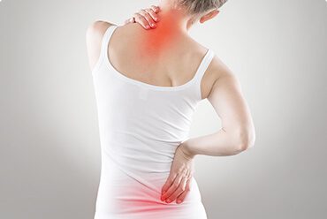 A woman in white shirt holding her back with red dot