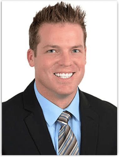 A man in suit and tie smiling for the camera.